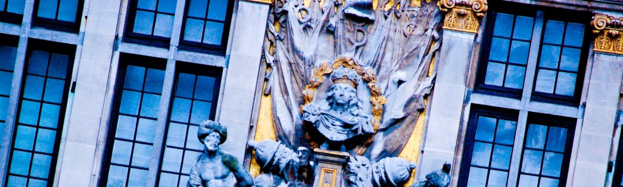 Blue-toned building with french-paned windows and gold statue